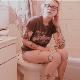 A blonde girl with tattoos and wearing glasses records herself shitting and pissing while sitting on a toilet. Audible plop sounds. Video has vintage sepia color tones. Product and dirty TP shown. 720P HD. Over 2 minutes.